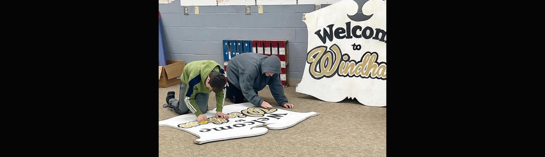 Junior high students work on painting a new community sign for Windham.