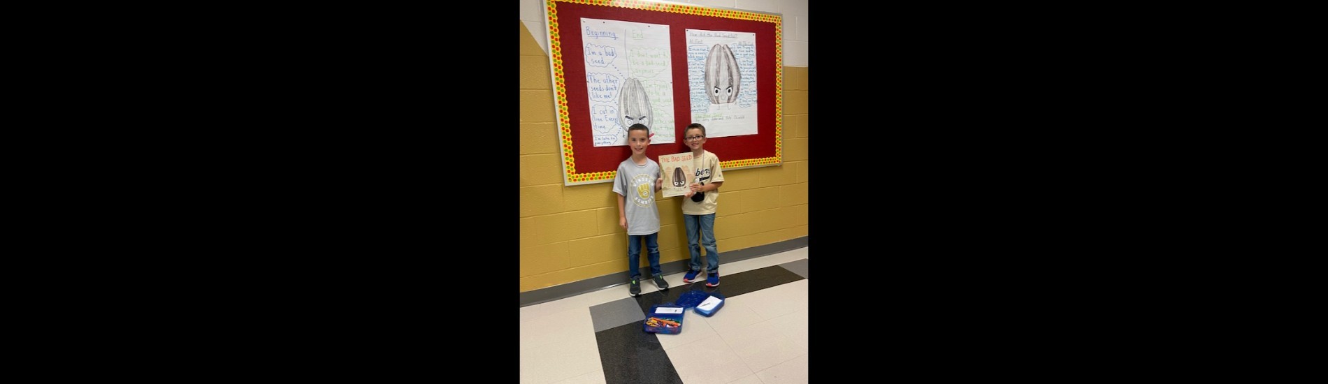 Two K.T. students pose with a book they read in class.